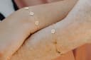 Gepersonaliseerde armband 4 bedels vier initialen gedragen aan de pols geelgoud verguld gftd. jewelry