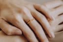 Mondasche-Ring aus gelbvergoldetem Metall, der am Finger getragen wird – ein Mondring mit Asche als Erinnerungsschmuckstück